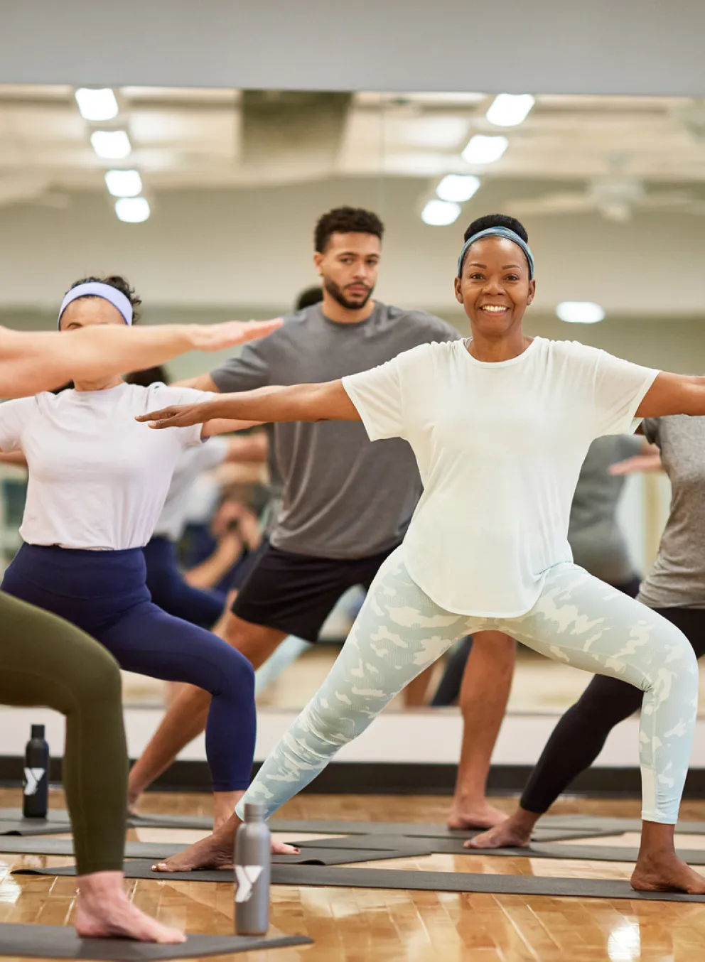 Y staff class leader and six workout class attendees stand and stretch before beginning the workout class; Find Your Y Photography