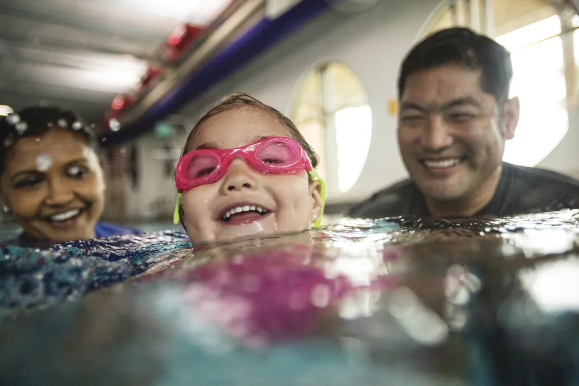young swimmer with 2 adults