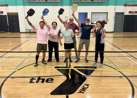 Group of Pickleball players smiling with their paddles